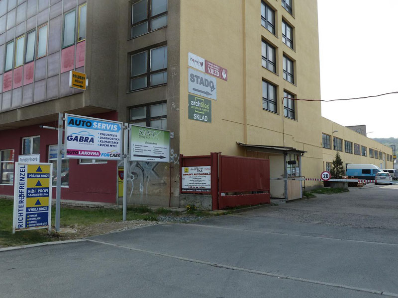 Ulice s budovou provozovny Forcars a informačními tabulemi