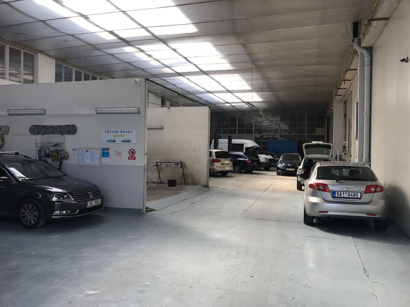 Dílna autoservisu s odstavenými osobními vozy