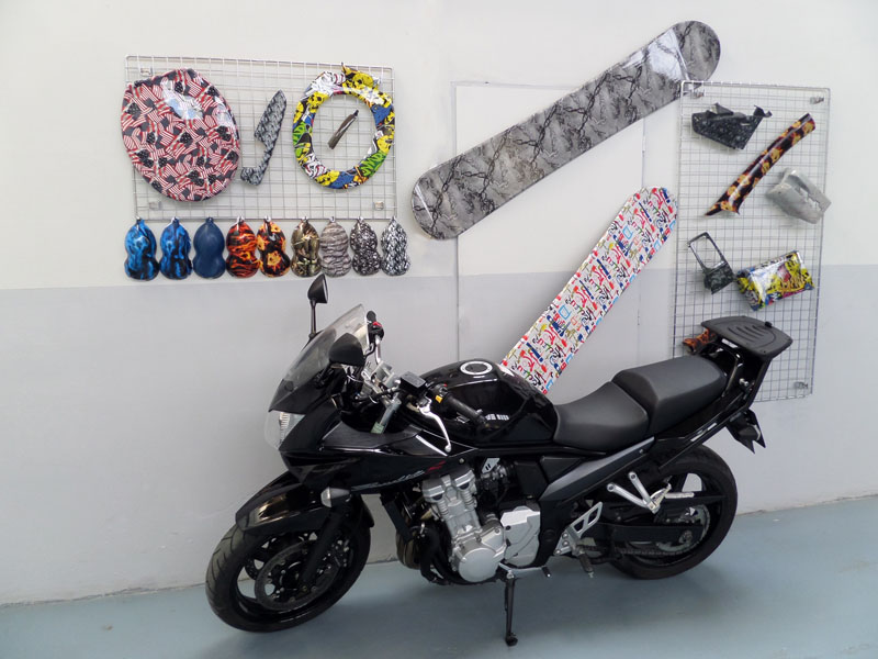 Motocykl v dílně a stěna s ukázkami hydrografiky